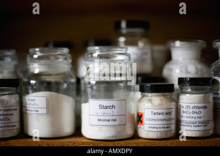 Memorizzazione vetro vasi contenenti le sostanze chimiche in un laboratorio scolastico Foto Stock