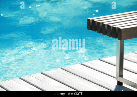 Banco vuoto al bordo della piscina Foto Stock