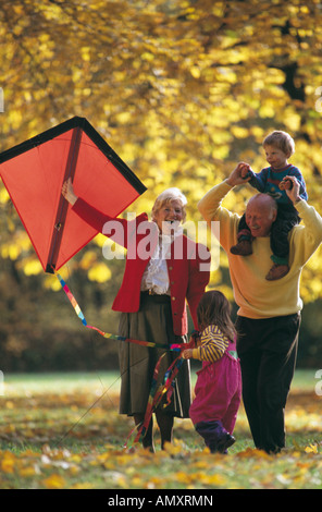 Coppia senior giocando con i loro nipoti in un parco Foto Stock