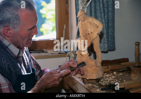 Scultore in legno facendo scultura in officina Tirolo Austria Foto Stock