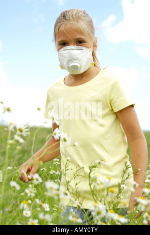 Ragazza con maschera in piedi in Prato Foto Stock