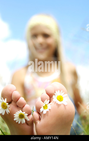 Ragazza che mostra fiori nei suoi piedi Foto Stock