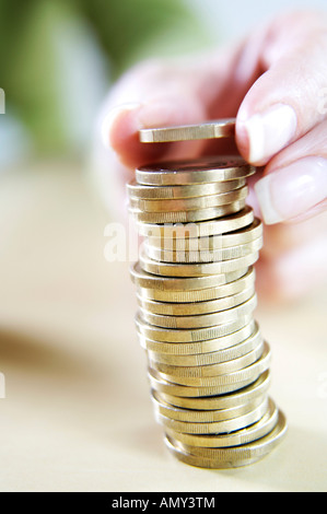 Edificio a mano un stackof monete metalliche in euro, close-up Foto Stock