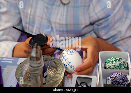 Dimostrazione di pittura delle uova presso le bancarelle del mercato in Piazza della Città Vecchia nel quartiere del centro storico di Praga, Repubblica Ceca Foto Stock