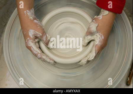 7-10 anni di bambino getta un vaso sulla ruota di vasai Foto Stock