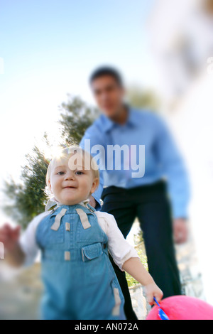 Little Boy giocare ''catch me se è possibile'' di uomo adulto Foto Stock