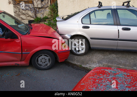 Bere Collisione azionamento su strada stretta tra due vetture una Ford Fiesta nel retro di un Rover parcheggiata e la scritta OFF Inghilterra Foto Stock