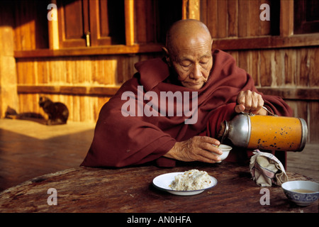 Anziani monaco buddista mangia colazione presso il monastero di Shwe Nuang Stato Shan Birmania Myanmar 2005 (c) Maciej Tomczak Foto Stock