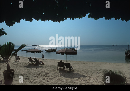 Rilassarsi sotto gli ombrelloni sulla spiaggia al di fuori del Tembo House Hotel e Serena hotel Old consolato US Stone Town Zanzibar Tanzania Foto Stock