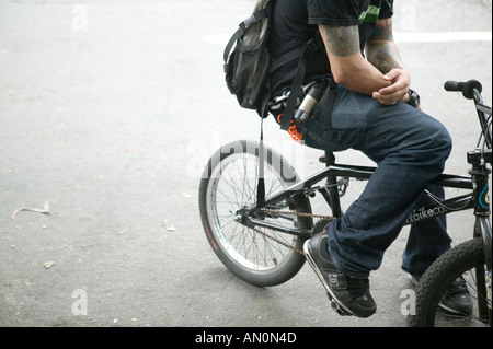 Tatuato ciclista seduto su una bicicletta BMX su una strada di giugno 2005 Foto Stock