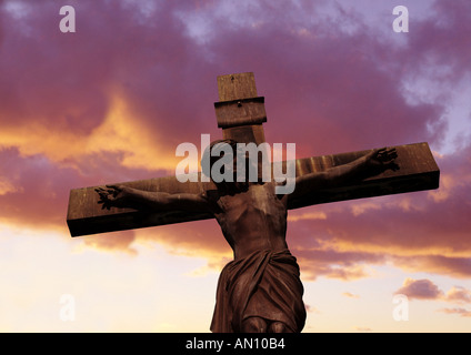 Statua di Gesù Cristo sulla croce al tramonto Foto Stock