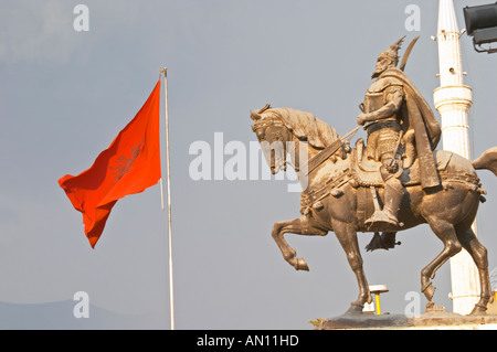 La statua del xv secolo un guerriero e un eroe nazionale Skanderbeg Skanderburg su un enorme base di pietra. Il rosso e il nero bandiera albanese. Il Tirana Piazza Centrale, Skanderburg Skanderbeg Square. Capitale Tirana. L'Albania, Balcani, Europa. Foto Stock