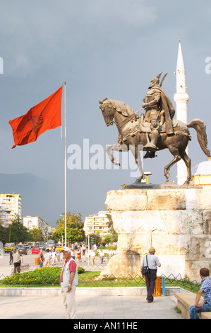 La statua del xv secolo un guerriero e un eroe nazionale Skanderbeg Skanderburg su un enorme base di pietra. Il rosso e il nero bandiera albanese. Il Tirana Piazza Centrale, Skanderburg Skanderbeg Square. Capitale Tirana. L'Albania, Balcani, Europa. Foto Stock