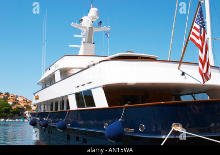 Un grande piacere di lusso con una barca a motore yacht nave, blu e bianco, American registrato con bandiera, con ville in background, ormeggiata in banchina chiave. Luka porto di Gruz. Dubrovnik, città nuova. Costa della Dalmazia, Croazia, Europa. Foto Stock