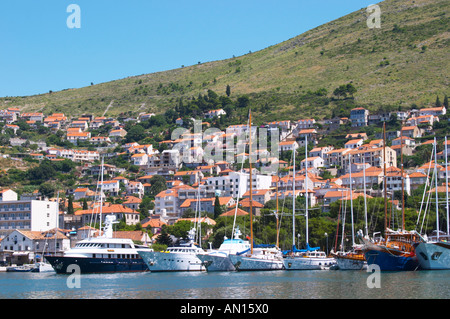 Più belle di crociera in legno, barca a vela e barche da pesca di navi Barche dipinte di bianco ormeggiate lungo che la chiave nel porto. Edifici moderni slitta verso la collina. Luka porto di Gruz. Dubrovnik, città nuova. Costa della Dalmazia, Croazia, Europa. Foto Stock