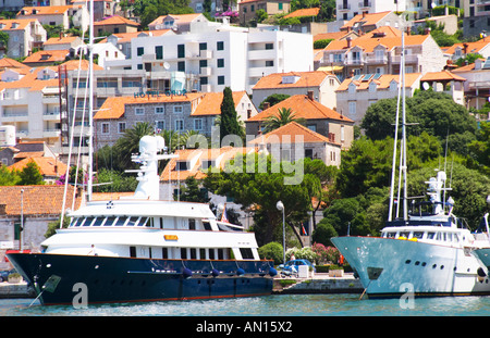 Un grande piacere di lusso con una barca a motore yacht nave, blu e bianco, American registrato con bandiera, con ville in background, ormeggiata in banchina chiave. Moderni edifici di appartamenti e hotel in background. Luka porto di Gruz. Dubrovnik, città nuova. Costa della Dalmazia, Croazia, Europa. Foto Stock