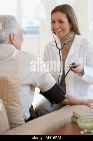 Femmina ispanica medico tenendo pressione del sangue del paziente Foto Stock