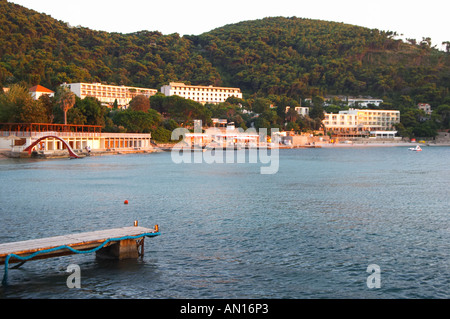 Spiaggia, pontile e alberghi in sera la luce del sole al tramonto. Uvala Sumartin bay tra la penisola di Babin Kuk e Lapad peninsula. Dubrovnik, città nuova. Costa della Dalmazia, Croazia, Europa. Foto Stock