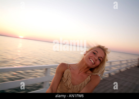 Stile di vita giovane donna per divertirsi in spiaggia, tramonto, retroilluminazione, chillout Foto Stock