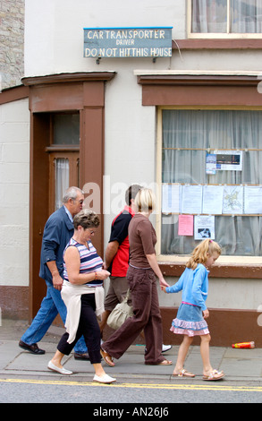 Le persone camminano davanti casa con un cartello di segnalazione sull angolo stretto nel villaggio di Talgarth in Montagna Nera Powys Wales UK Foto Stock