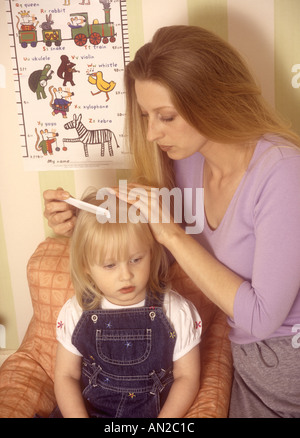 Madre controllo giovani ragazze capelli per pidocchi della testa Foto Stock