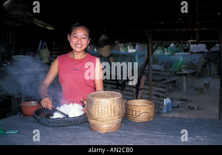 Donna gentile presso un ristorante locale la vendita di riso appiccicoso villaggio sulla riva opposta del Mekong a Luang Prabang, Laos Foto Stock