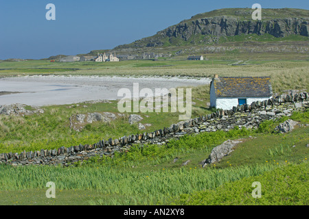 Isola di Oronsay Scozia che mostra il vecchio kelpers cottage di spiaggia di sabbia bianca e il priorato di distanza Giugno Foto Stock