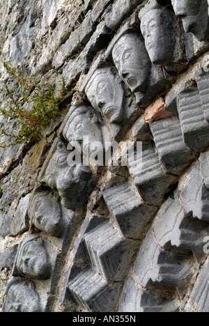 Scolpite le teste di pietra intorno al portale romanico in Dysert O dea Chiesa County Clare Irlanda Foto Stock