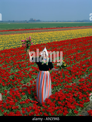 Campi di Tulipani / ragazza vestita in Costume olandese in campi di tulipani Lisse, Olanda Foto Stock