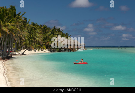 Un turista in kayak che si avvicina ad una spiaggia di Aitutaki, le Isole Cook Foto Stock