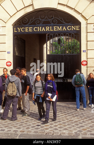 Liceali francesi di scolari e scolare sempre insieme in corrispondenza del recesso al Lycee Carlo Magno nel quartiere Marais di Parigi Francia Foto Stock