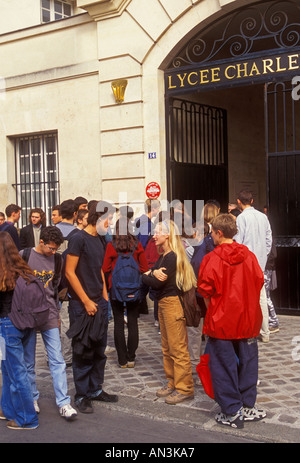 Liceali francesi di scolari e scolare sempre insieme in corrispondenza del recesso al Lycee Carlo Magno nel quartiere Marais di Parigi Francia Foto Stock