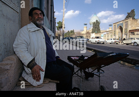 Venditore ambulante seduta sul marciapiede, Iran Foto Stock