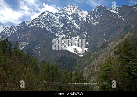 Il trekking attraversando un ponte di sospensione. Al di là di Bhratang villaggio sul modo per abbassare Pisang. Circuito di Annapurna trek. Il Nepal Foto Stock