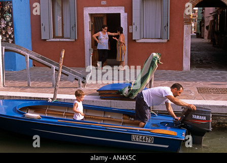 Uomo con figlio sulla barca in canal, Murano, Venezia Foto Stock