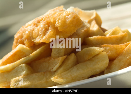 Pesce e patatine patate unte spuds attacco di cuore di grassi alimentari grassi friggere olio profondo pastella obesse antigoccia su peso veloce il cibo tradizionale Foto Stock