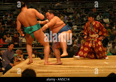 Punto di vittoria per un lottatore di sumo che spinge il suo avversario fuori del sacro dyho ad anello a molla torneo di sumo in Osaka Foto Stock