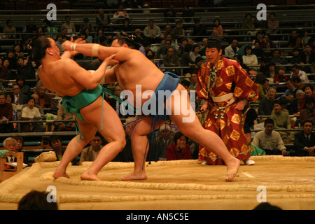 Punto di vittoria per un lottatore di sumo che spinge il suo avversario fuori del sacro dyho ad anello a molla torneo di sumo in Osaka Foto Stock