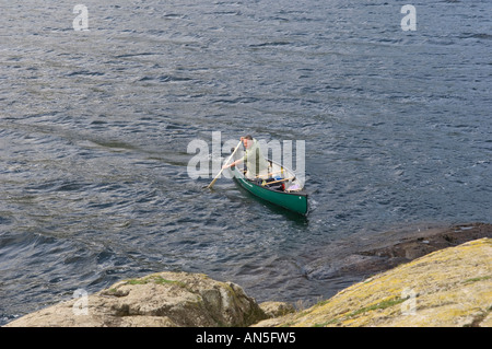 Un canoeist sguazzare un Mad River Canoa Explorer 16 sull'Ullswater Lake District Cumbria Inghilterra England Foto Stock