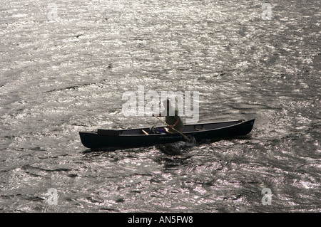 Un canoeist sguazzare un Mad River Canoa Explorer 16 sull'Ullswater Lake District Cumbria Inghilterra England Foto Stock