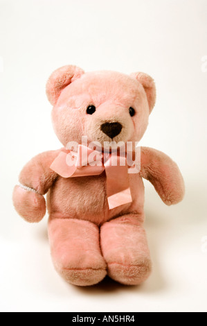 Leggermente sporchi vecchi rosa per bambini orsacchiotto su sfondo bianco contro uno sfondo bianco in studio Foto Stock