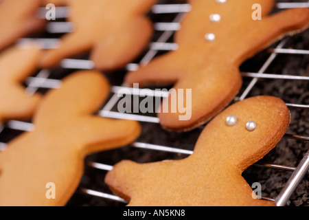 Gingerbread uomini raffreddamento sulla rastrelliera metallica graite sulla superficie di lavoro Foto Stock