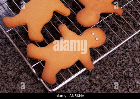 Gingerbread uomini raffreddamento sulla rastrelliera metallica su granito superficie di lavoro Foto Stock