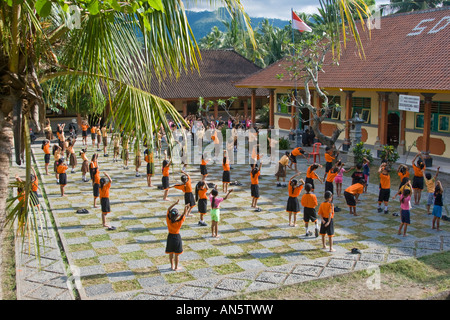 I bambini della scuola di mattina facendo esercizi di Stretching Bali Indonesia Foto Stock