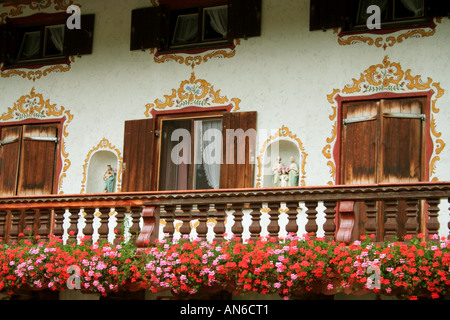 Balcone con fiori e arte sacrale presso un agriturismo bavarese vicino a Bad Toelz in Germania Foto Stock