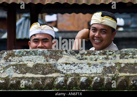 Uomini sorridenti durante la cerimonia Odalan a pura Basukian o Besakih Puseh Jagat tempio indù Bali Indonesia Foto Stock