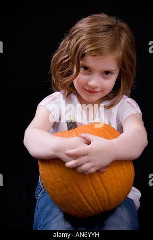 Bella bambina di cinque anni mentre tiene il suo zucca Foto Stock