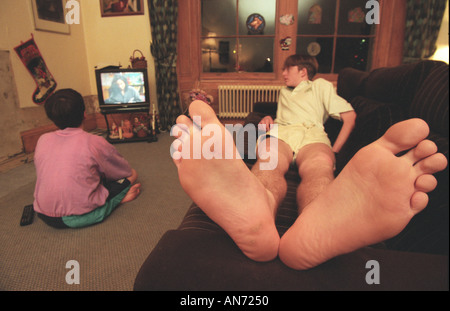 Piedi grandi su un couch potato REGNO UNITO Foto Stock