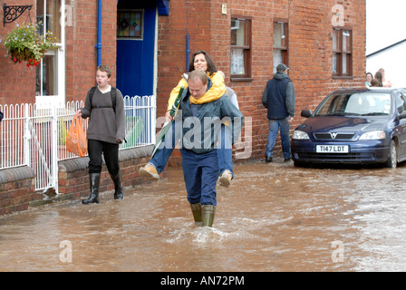 Uomo che porta la donna attraverso le inondazioni in Tenbury Wells Giugno 2007 Foto Stock