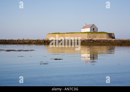 Storica del XII secolo Llangwyfan chiesa sulla piccola isola di marea attraverso acqua a Porth Cwyfan Aberffraw Anglesey North Wales UK Foto Stock